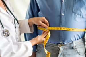 A man getting his measurements taken by a doctor at a weight loss clinic.