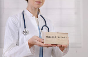 A hormone doctor holding building blocks that say hormone balance.
