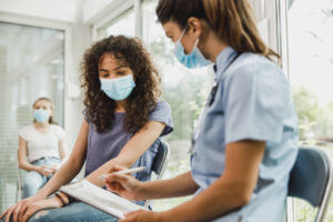 A young adolescent speaking to her family medicine provider about the stages of puberty and what she should expect.